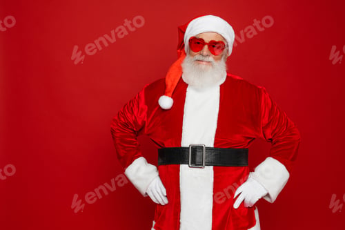 Preview: Positive santa claus wear red sunglasses costume isolated over bright shine color red background