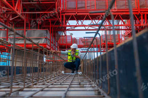 Preview: architect engineer designing a structure holding tablet, walkie talkie, drawing
