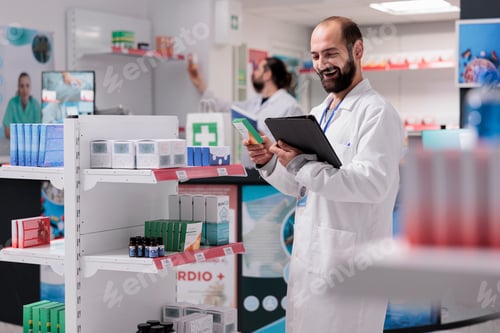 Preview: Pharmacist looking at vitamins packages being responsible for accurately filling and labeling