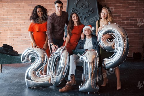 Visualização: Lindos jovens amigos, se divertindo na véspera de Ano Novo, com números para 2019