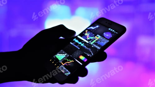 Preview: Hand holding mobile and graphs of currency exchange on screen