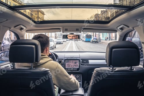 Preview: A male driver drives at speed through the streets of the city.