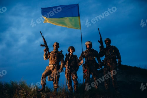 Preview: Portrait of four armed Ukrainian militarymen with a national flag in the evening.