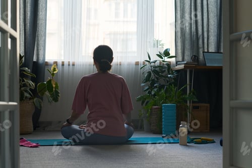 Preview: Woman Practicing Meditation on Yoga Mat Indoors