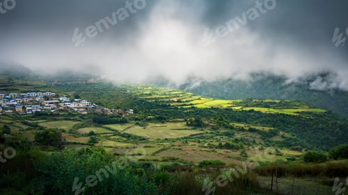 Preview: a lush green valley is surrounded by hills and fields with fog rising