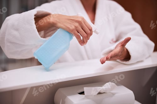 Preview: Woman disinfecting her hands at the beauty salon reception desk