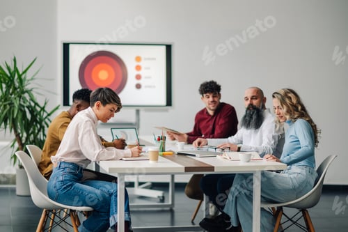 Preview: Marketing professionals collaborating on project in modern office meeting room