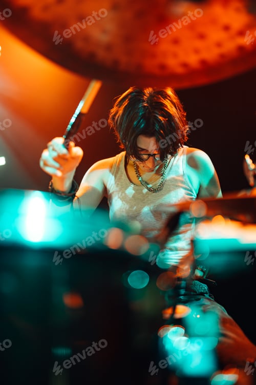 Preview: Drummer playing with drumsticks on illuminated stage
