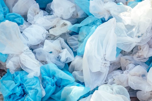 Preview: white used medical shoe covers in trash. the concept of hygiene and protection.