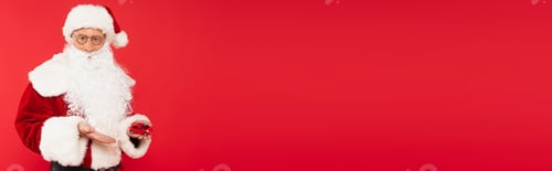Preview: Father christmas pointing at model of car isolated on red, banner