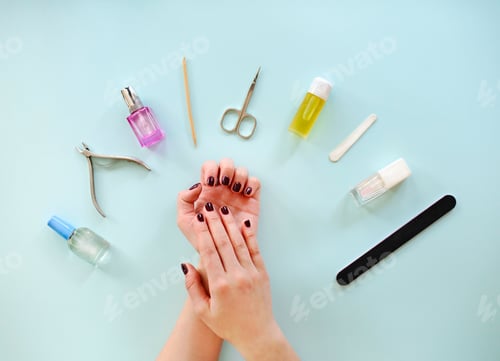 Preview: Top view of crop anonymous female with dark manicure sitting at table with various tools