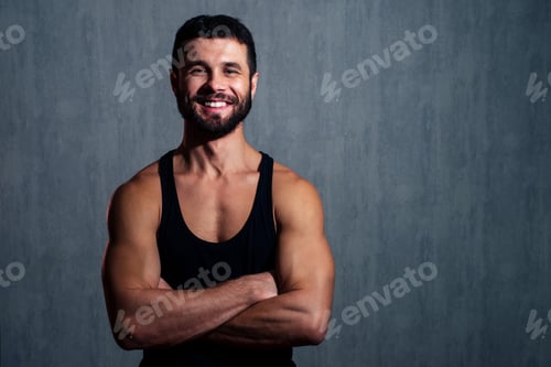 Preview: muscular healthy man in black T-shirt on dark background.
