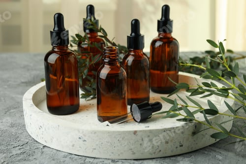 Preview: Tray with bottles of eucalyptus oil and branches on gray table