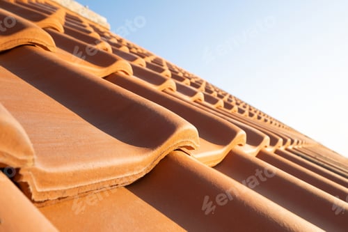 Preview: Overlapping rows of yellow ceramic roofing tiles covering residential building roof