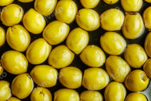 Preview: Sliced pickled green olives in brine. Top view.