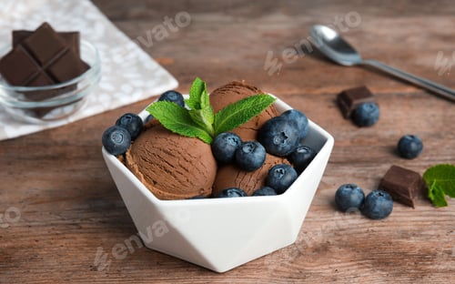 Preview: Bowl of chocolate ice cream and blueberries served on wooden table, space for text