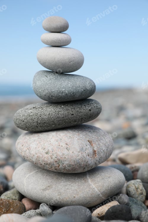 Preview: Stack of stones on beach against blurred background, closeup