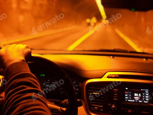 Preview: A man driving down the road going through a tunnel with orange glow