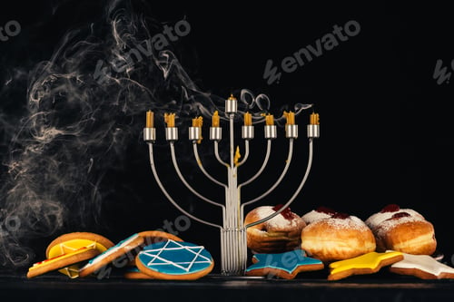 Preview: traditional jewish menorah for hanukkah celebration, doughnuts and cookies, isolated on black