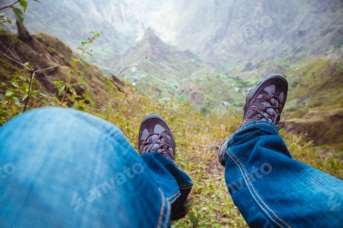 Preview: Traveler hiking boots over impressive verdant Xo-Xo valley with mountain peaks, rugged cliffs on