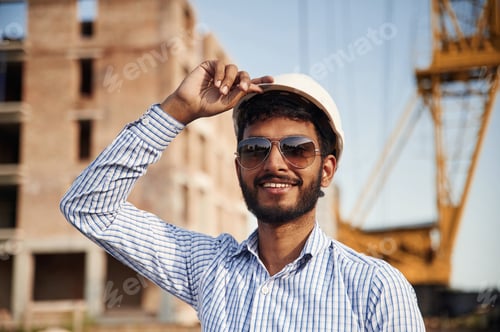 Preview: Portrait of handsome Indian man that is on the construction site