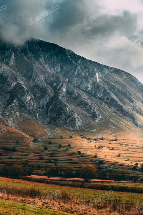 Preview: Hills covered in yellowing trees and fog on a cloudy day in autumn in the countryside
