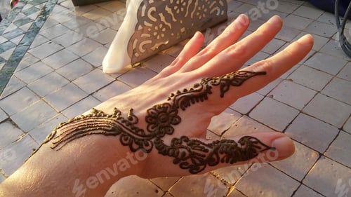 Preview: Hand painted gems to a young woman in the Marrakech square. Morocco