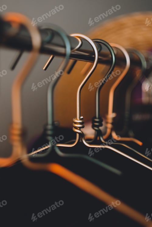 Preview: Metal clothes hanger, warm light, close-up. Fashion concept, wardrobe.