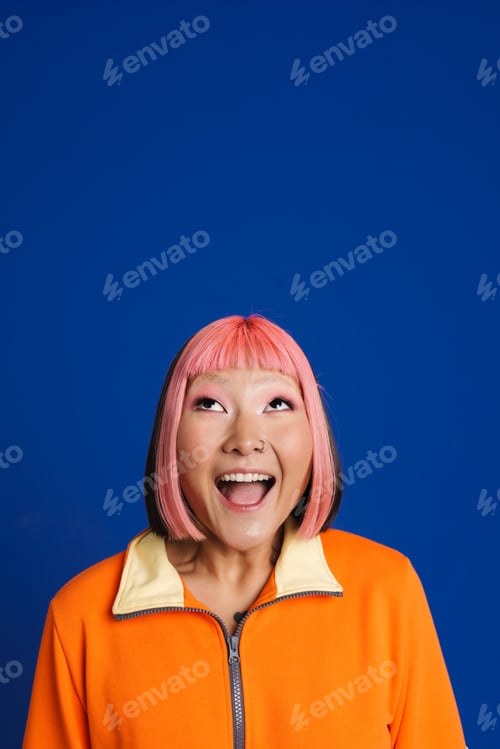 Preview: Asian girl with pink hair and piercing expressing surprise at camera