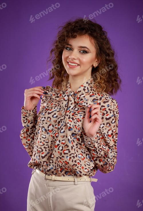 Preview: A vertical portrait of a young curly-haired girl smiling and put her hands to her chest