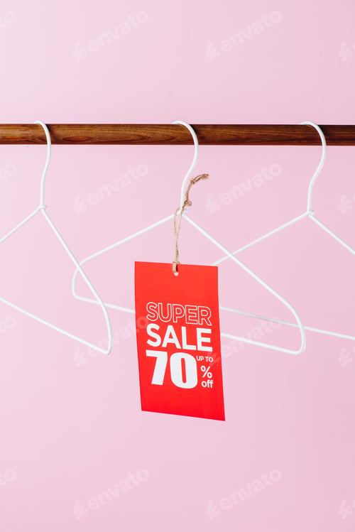 Preview: hangers with red super sale tag - seventy percents discount on pink