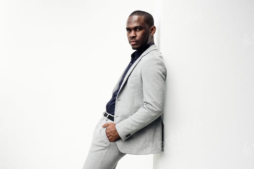 Preview: Side of fashionable african american business man leaning against white wall