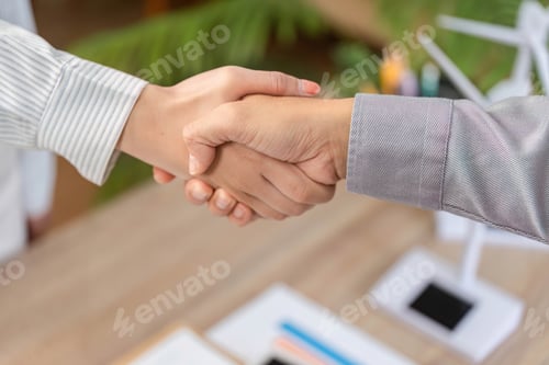 Preview: ESG Partnership Agreement. Business professionals shaking hands in an office setting.