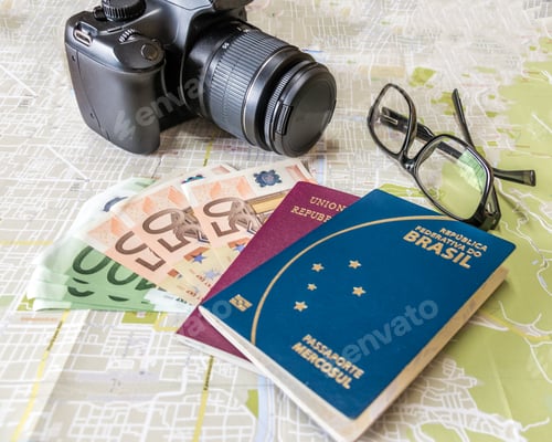 Preview: Brazilian and Italian passports on city map with euro bills money, camera and glasses