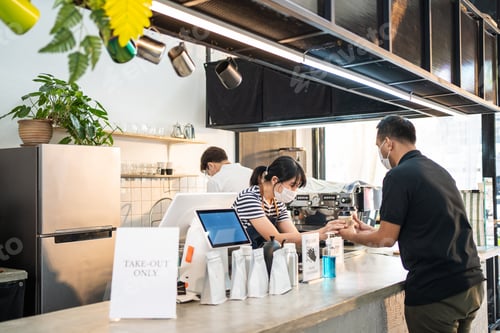 Preview: Asian Man customer wear mask due to Covid-19 pandemic, receive drink from waiter on coffee bar.