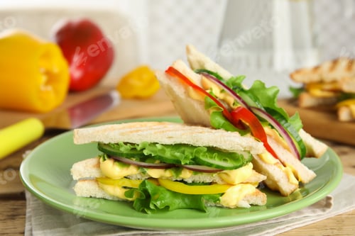 Preview: Green plate with tasty sandwiches on table