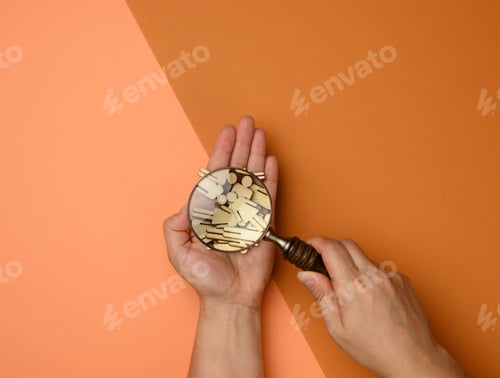 Preview: Wooden men and a magnifying glass on a brown background. Recruitment concept