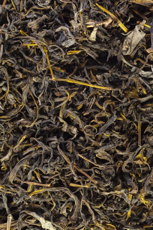 Preview: Close view of dry tea leaves on a surface with natural texture and color variations