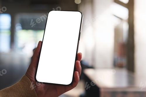 Preview: Mockup image of a woman holding and using mobile phone with blank desktop in cafe