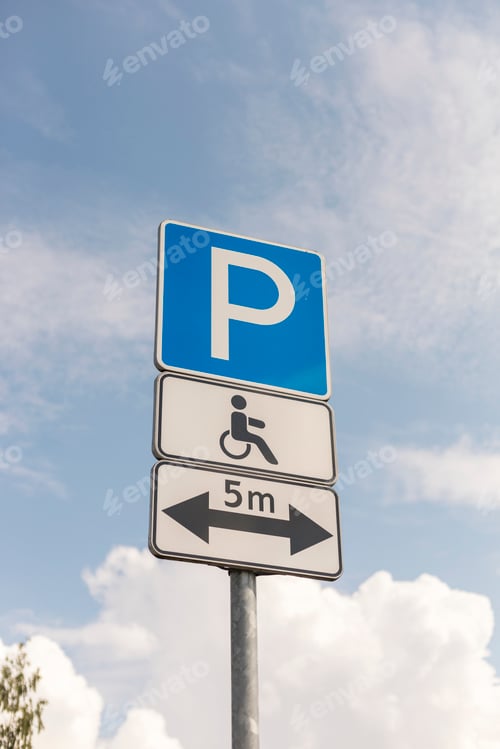 Preview: Parking sign stands tall against blue sky. It designates parking area with symbol for accessible