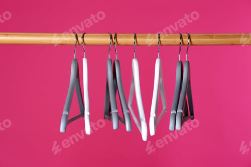 Preview: Wooden rack with clothes hangers on color background