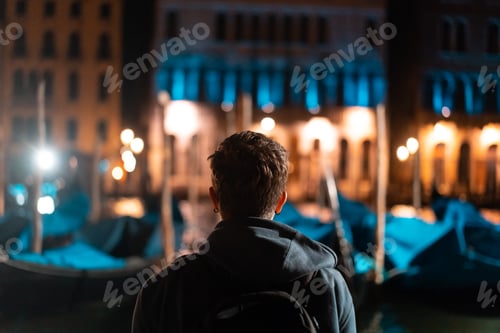 Visualização: Jovem bonito caminha sozinho por Veneza à noite