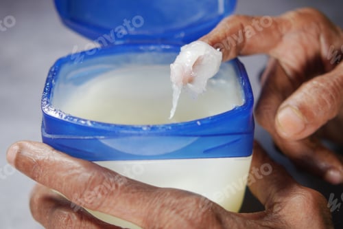 Preview: senior woman using petroleum jelly onto skin