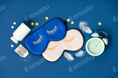 Preview: Blue and pink sleeping masks, pills and herbal tea on blue background