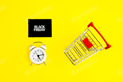 Preview: A white alarm clock, a shopping cart, and a black square that says black Friday on yellow background