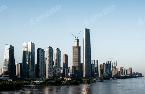 Preview: Of modern skyscrapers along a river in a city during daytime.