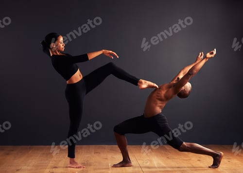 Preview: A female and male contemporary dancer performing a dramatic pose in front of a dark background