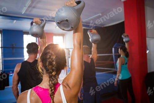 Preview: Rear view of young athletes lifting kettles