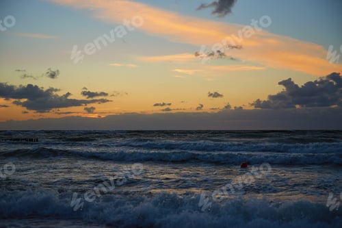 Preview: Sea landscape with waves against cloudy sunset sky