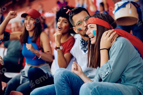 Preview: Young happy people celebrating victory of their favorite team while watching sports game at stadium.